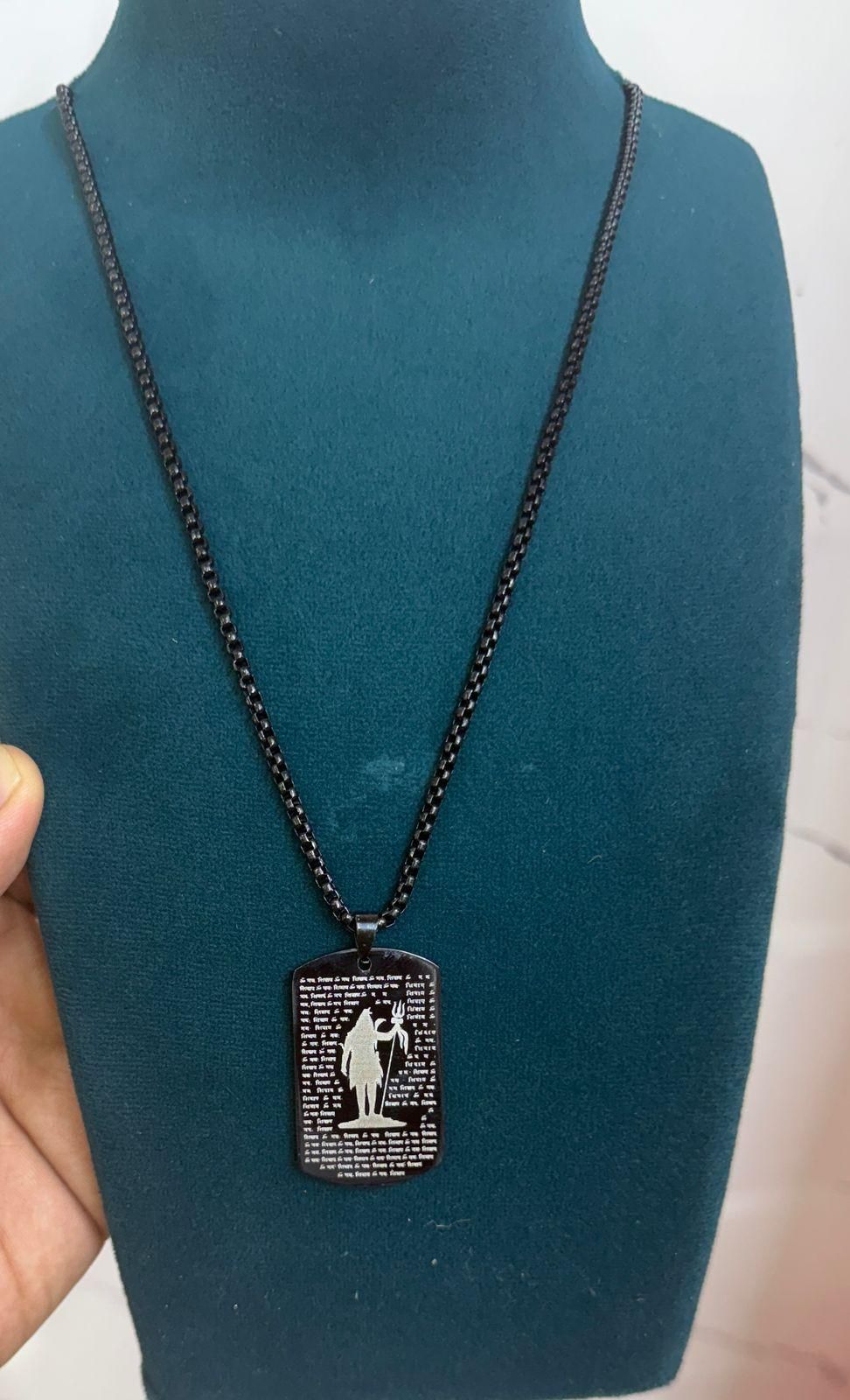 108 Om Namah Shivay pendant on a black chain displayed on a teal jewelry stand