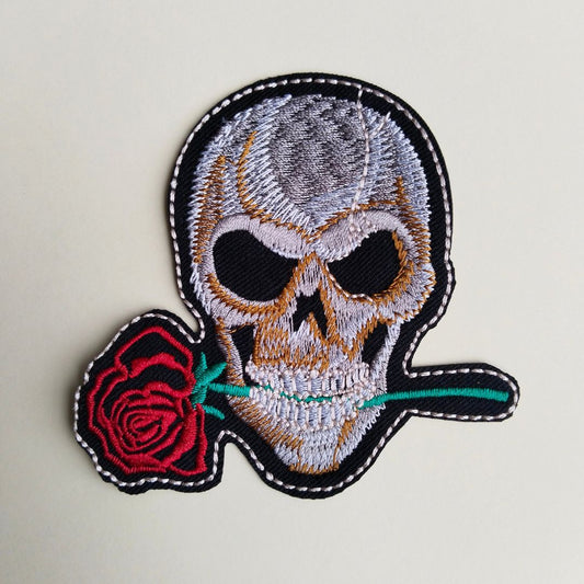 Embroidered patch with a skull and red rose on a light gray background