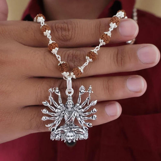 Sitted Shiva silver pendant on a necklace, featuring intricate details and a multi-armed design